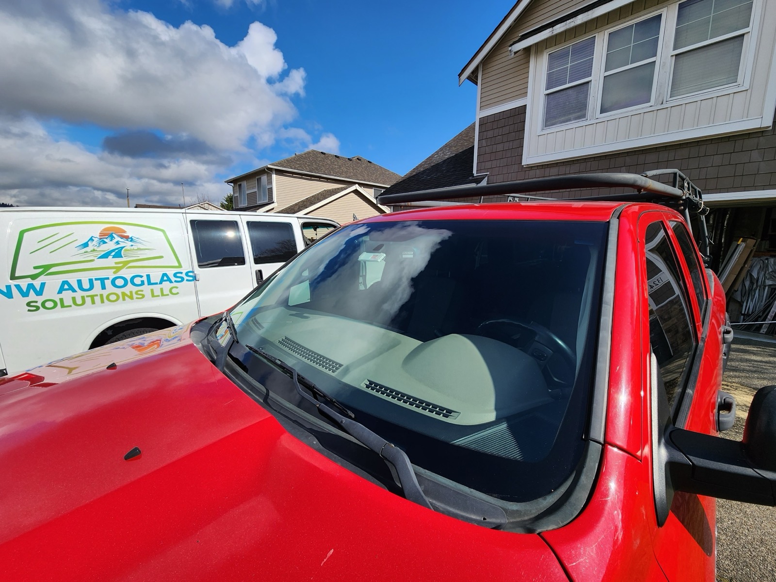 NW Autoglass Solutions mobile van beside a red Jeep after a windshield replacement in Pierce County